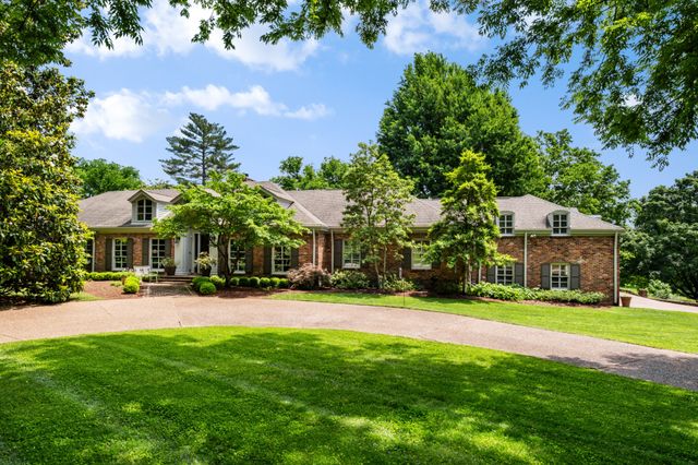 a view of a house with a yard and basketball ground