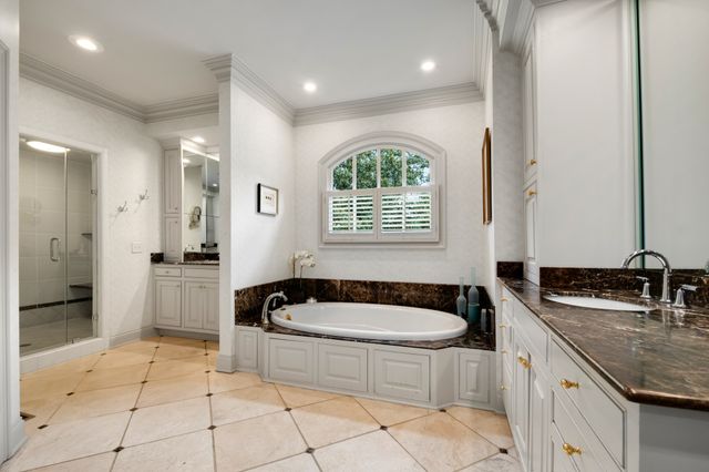 a bathroom with a granite countertop tub sink and mirror