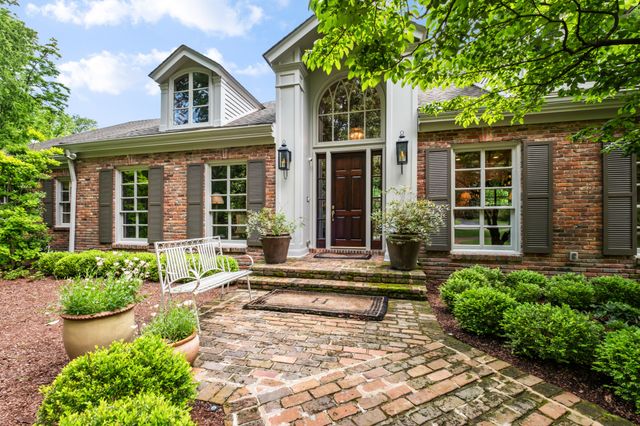 a front view of a house with a yard and potted plants