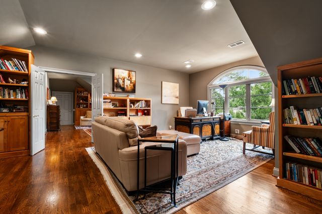 a living room with furniture a flat screen tv and a large window