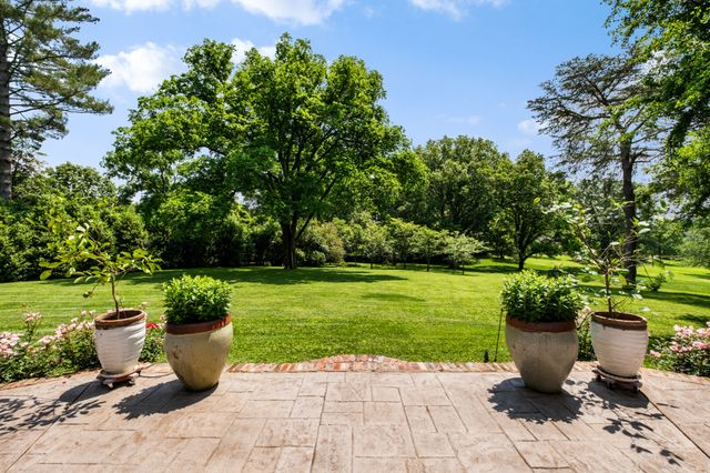 a view of a patio with dining table and chairs with a garden