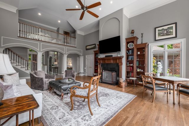 a living room with fireplace furniture and a large window