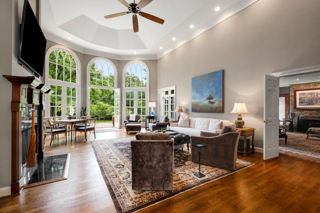 a living room with furniture a large window and a flat screen tv