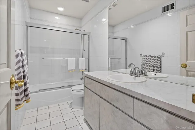 a bathroom with a granite countertop sink a toilet and shower