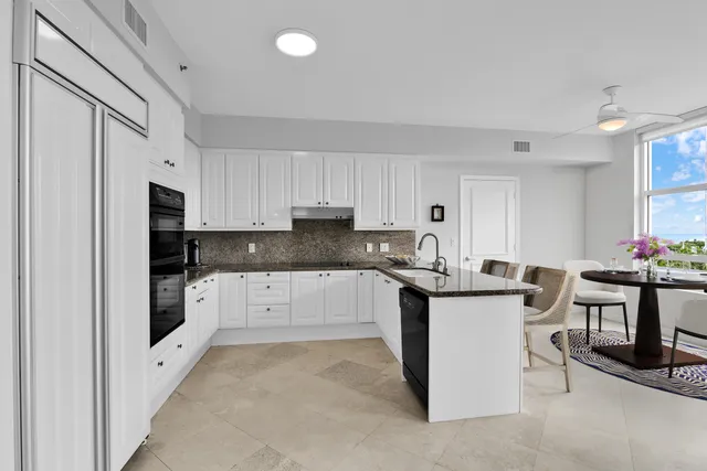 a spacious bedroom with a bed couch chandelier and a window