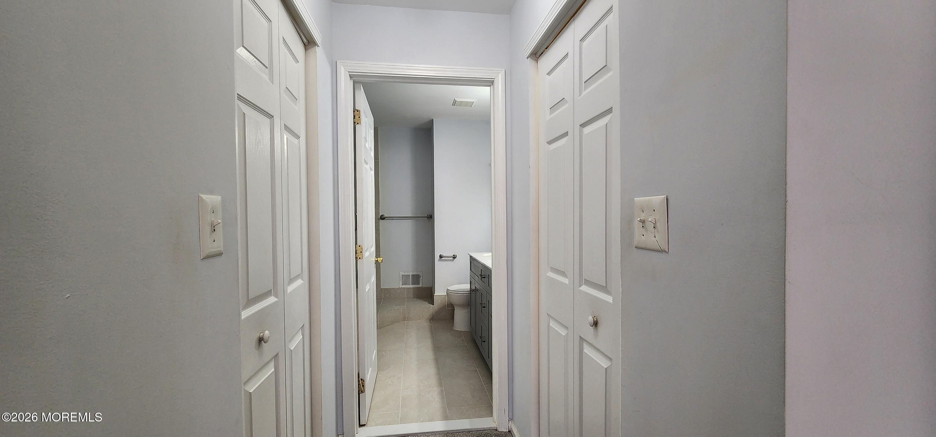 117 Mid Ocean Court, Unit 1000 Howell, NJ 07731 - Photo 17 of 24 a view of a bathroom from a corridor