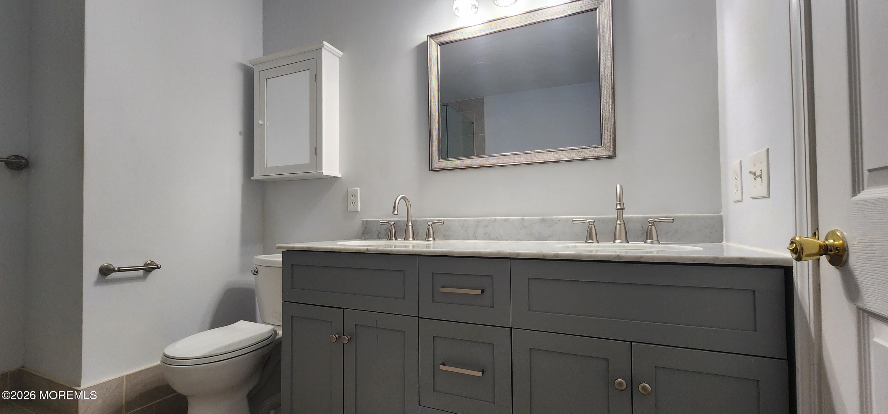 117 Mid Ocean Court, Unit 1000 Howell, NJ 07731 - Photo 20 of 24 a bathroom with a toilet sink and mirror