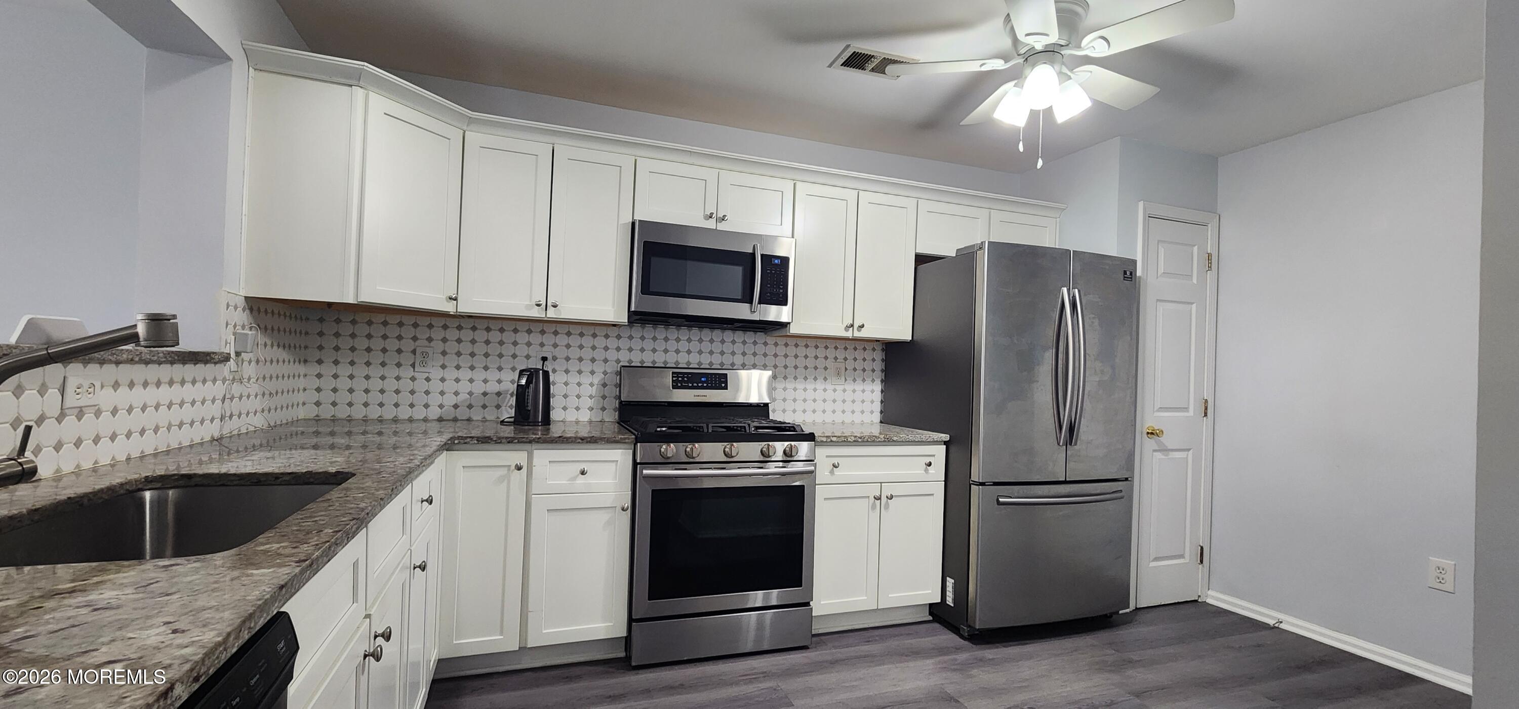 117 Mid Ocean Court, Unit 1000 Howell, NJ 07731 - Photo 7 of 24 a kitchen with a sink stove and refrigerator