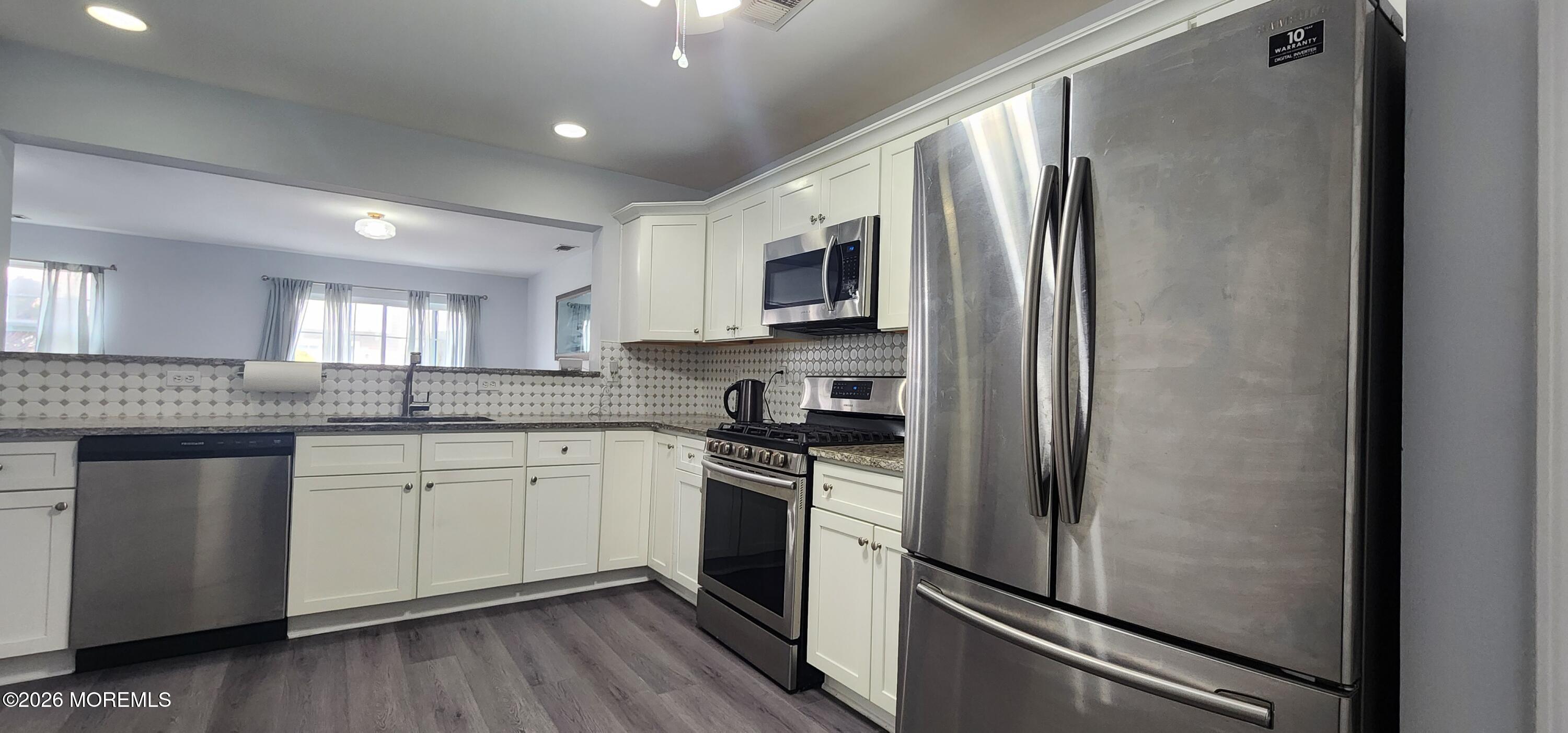 117 Mid Ocean Court, Unit 1000 Howell, NJ 07731 - Photo 8 of 24 a kitchen with stainless steel appliances granite countertop a refrigerator stove and sink