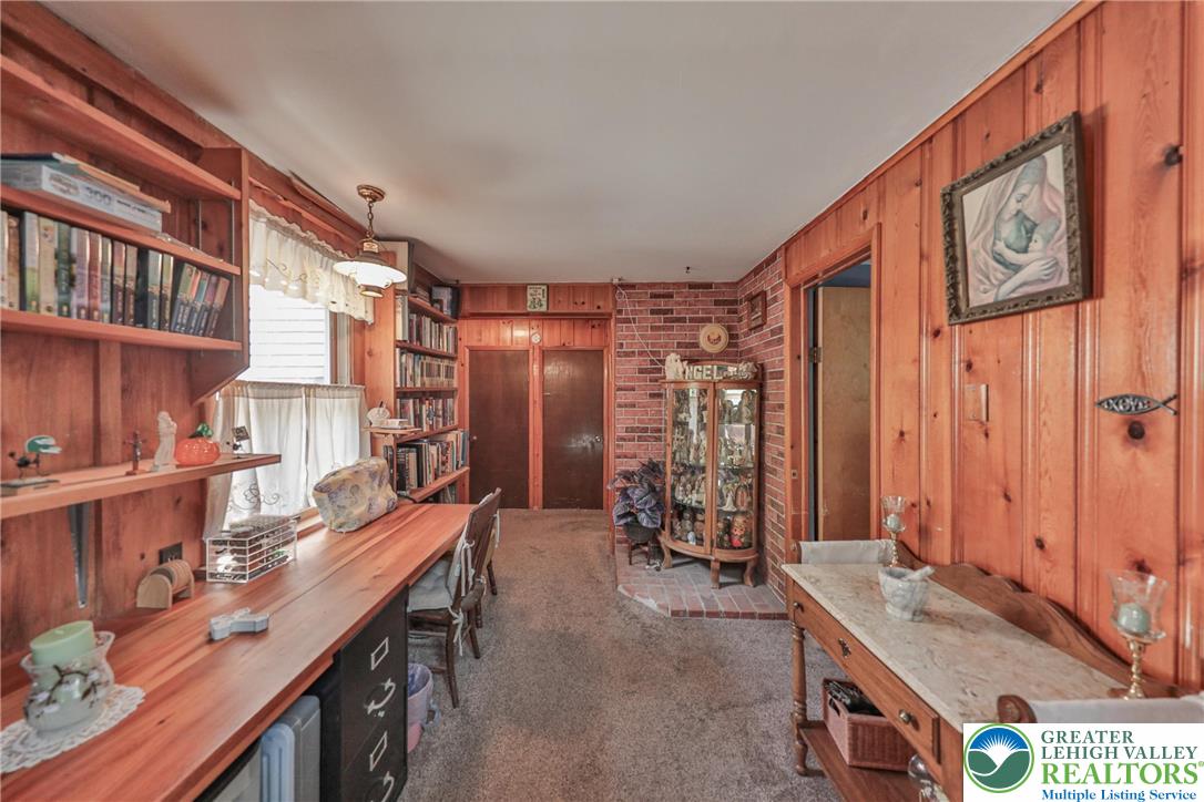 331 Cranberry Creek Road Cresco, PA 18326 - Photo 26 of 95 Natural wood paneling and extensive built-in shelving define this versatile living area, ideal for a home office or library.