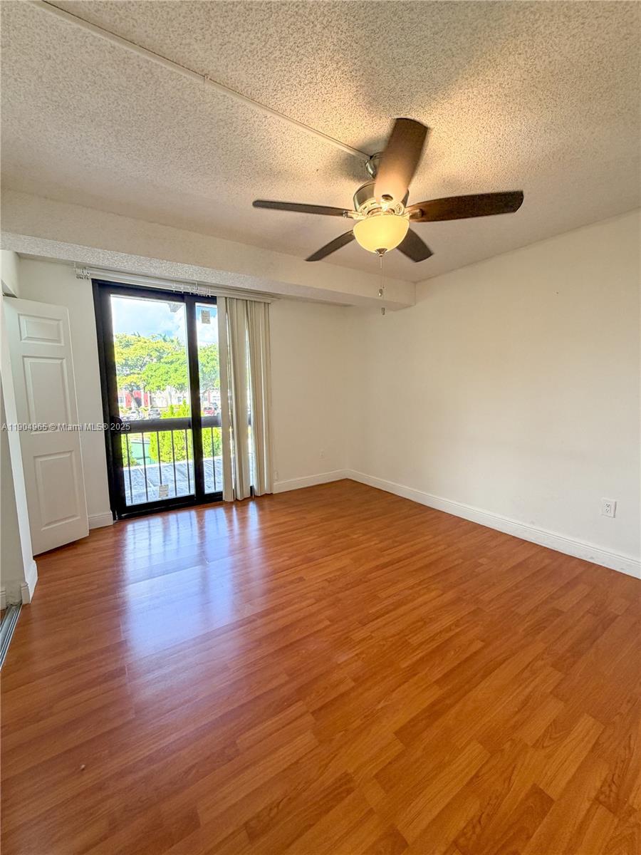 1790 Southwest 122nd Place, Unit 102X Miami, FL 33175 - Photo 6 of 12 a view of an empty room with wooden floor and a window
