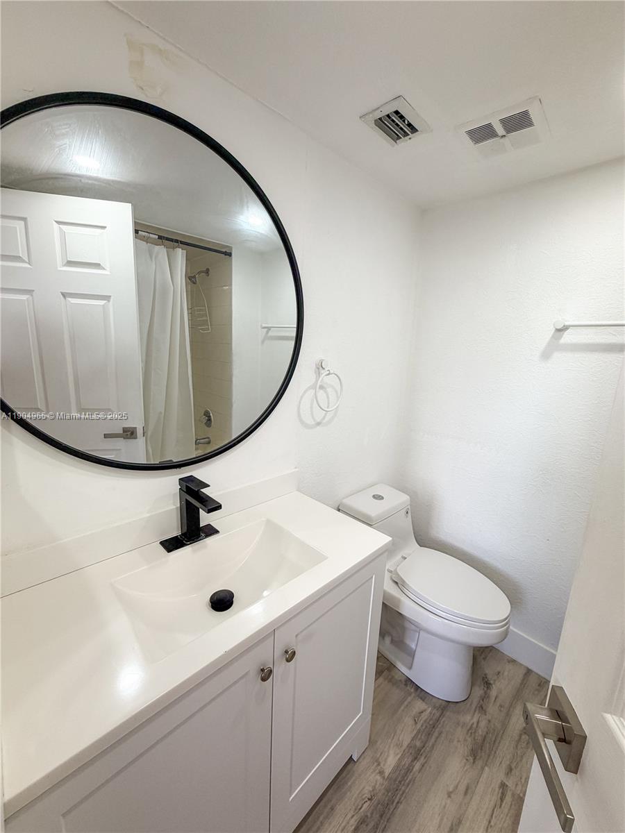 1790 Southwest 122nd Place, Unit 102X Miami, FL 33175 - Photo 9 of 12 a bathroom with a sink a toilet and mirror