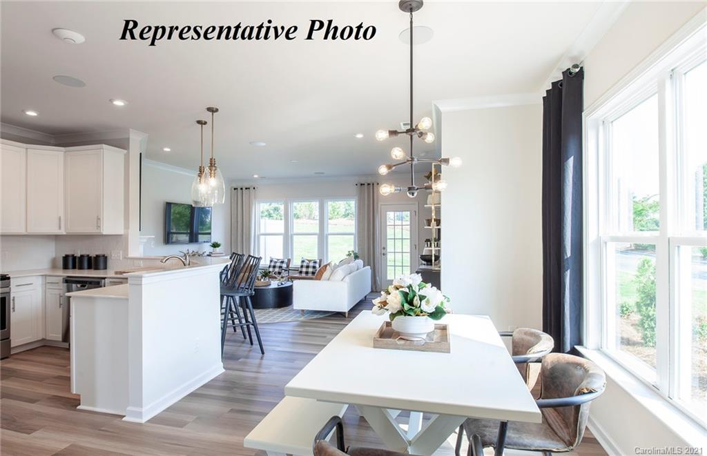 725 Elders Story Road, Unit 347 Fort Mill, SC 29708 - Photo 3 of 18 a living room with stainless steel appliances kitchen island granite countertop a table chairs and a view of living room