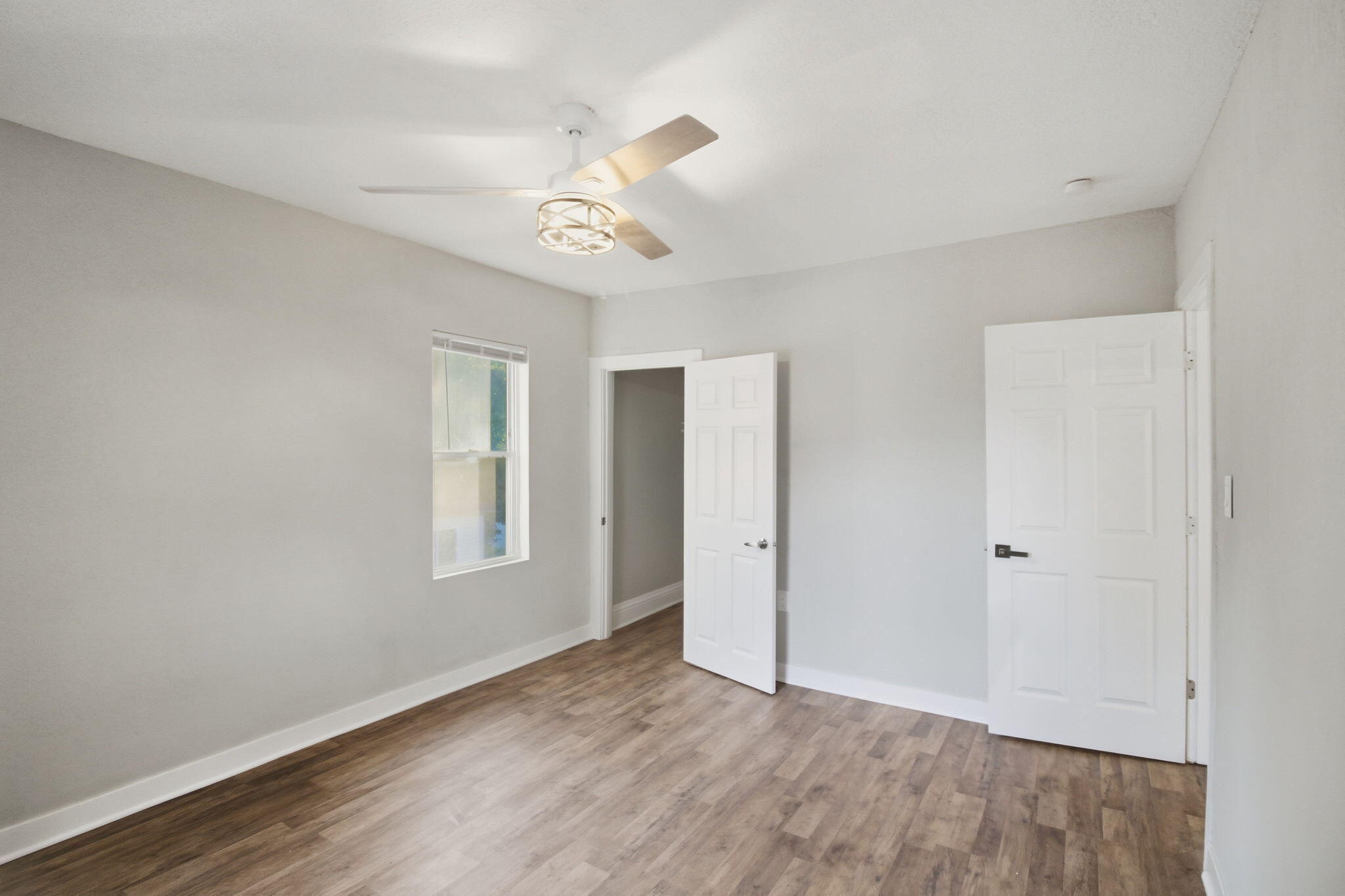 537 Harrison Street Gary, IN 46402 - Photo 15 of 24 an empty room with wooden floor ceiling fan and windows