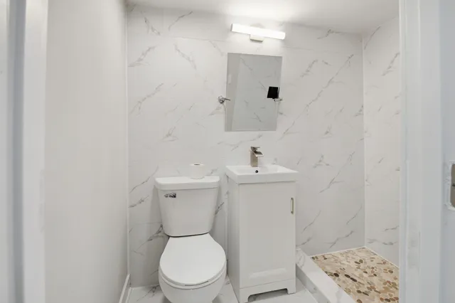 a white toilet sitting next to a bathroom sink
