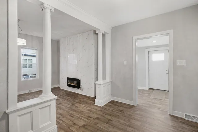 a view of a livingroom with wooden floor and a fireplace
