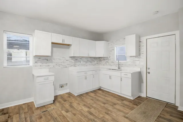 a kitchen with granite countertop white cabinets and white appliances