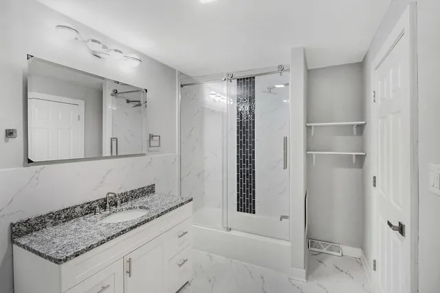 a bathroom with a granite countertop sink and a mirror