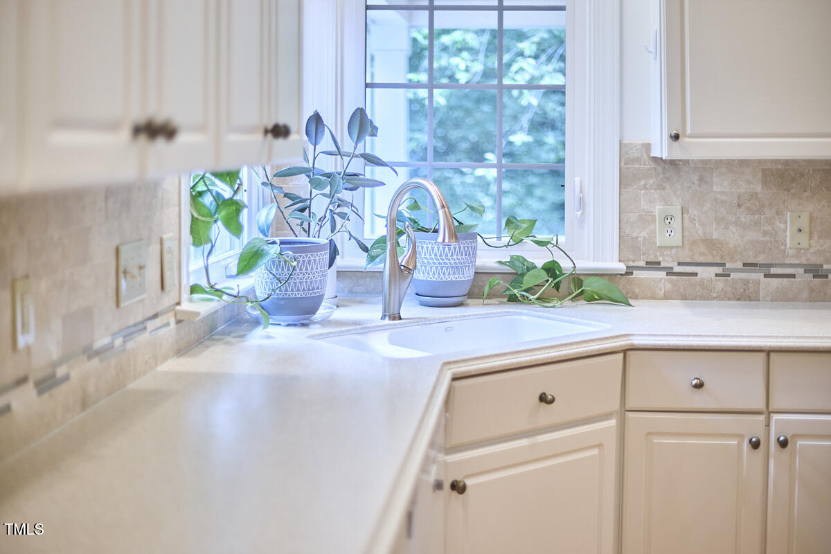 8605 Stanton Place Raleigh, NC 27615 - Photo 24 of 56 a kitchen with granite countertop a white sink and white cabinets