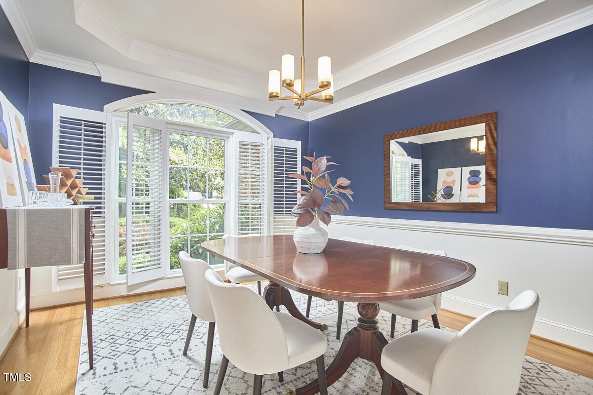 8605 Stanton Place Raleigh, NC 27615 - Photo 27 of 56 a dining room with furniture a rug and a chandelier