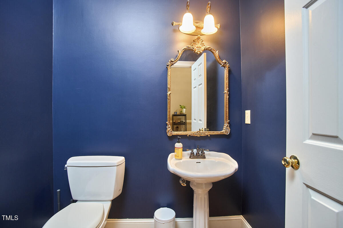 8605 Stanton Place Raleigh, NC 27615 - Photo 36 of 56 a bathroom with a toilet sink and mirror