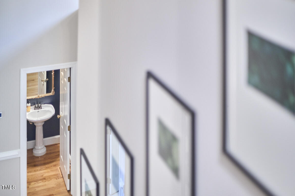 8605 Stanton Place Raleigh, NC 27615 - Photo 37 of 56 a view of a hallway with wooden floor and a living room
