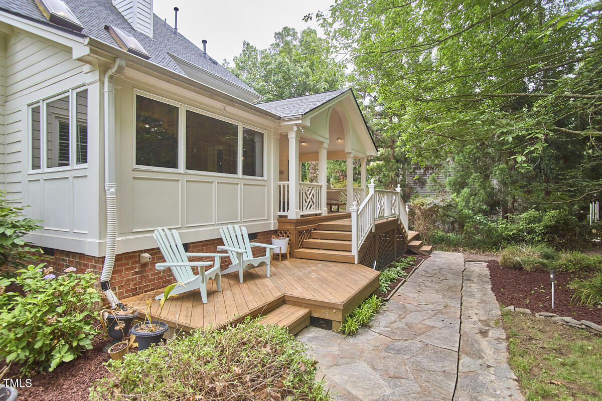 8605 Stanton Place Raleigh, NC 27615 - Photo 47 of 56 a view of a patio with table and chairs with wooden fence and plants