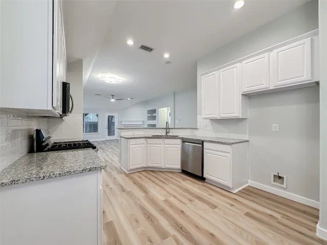 a kitchen with granite countertop white cabinets and white appliances
