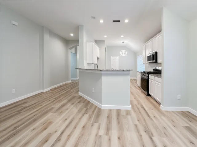 a view of kitchen with granite countertop cabinets and wooden floor