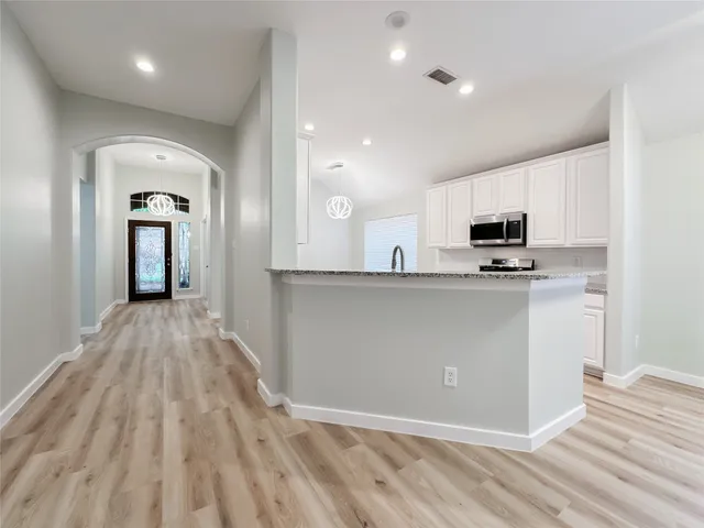 a view of kitchen with wooden floor and electronic appliances