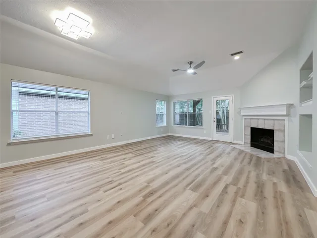 a view of empty room with wooden floor and fireplace