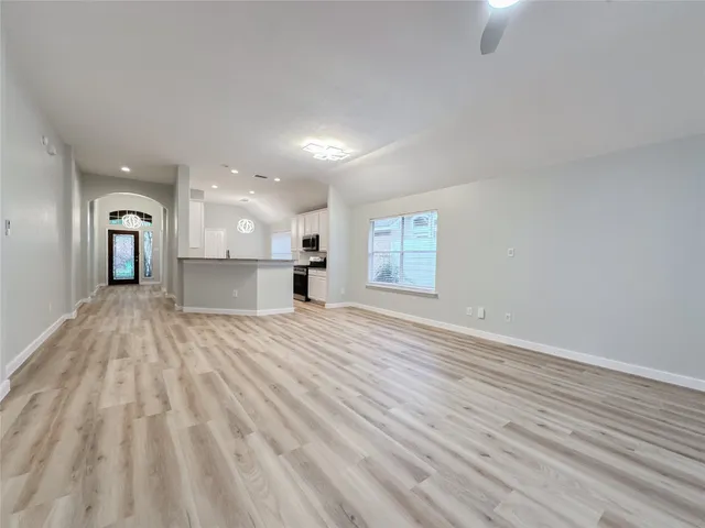 a view of empty room with wooden floor