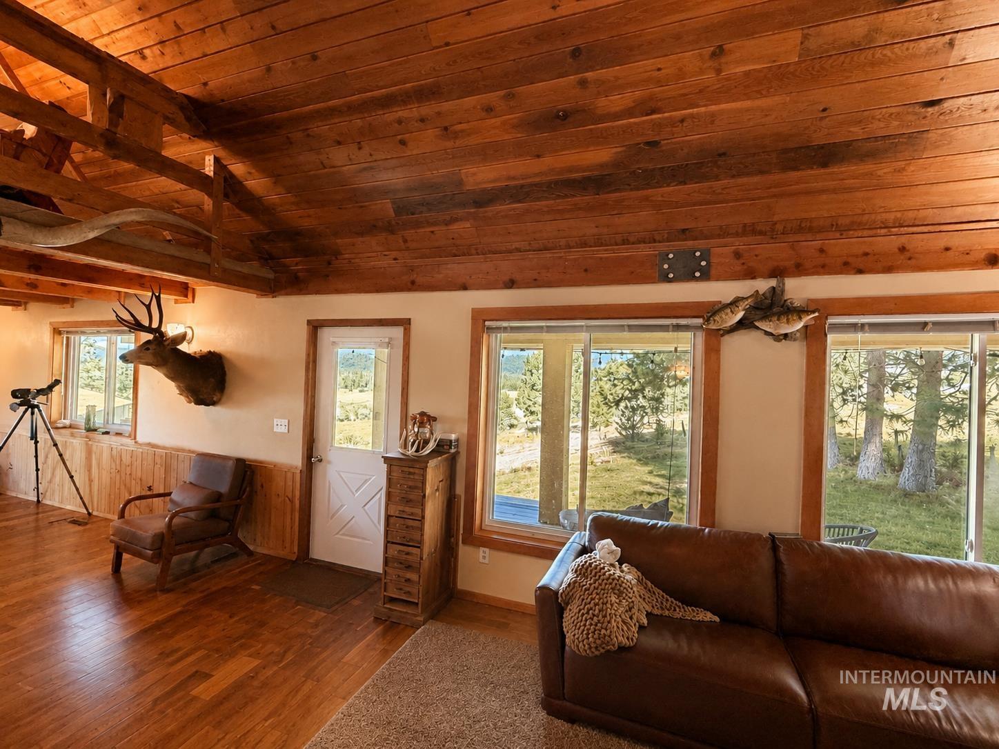 40 Atkin Lane Cascade, ID 83611 - Photo 7 of 46 Covered outdoor patio with dark composite decking and a mounted bell, overlooking expansive green acreage