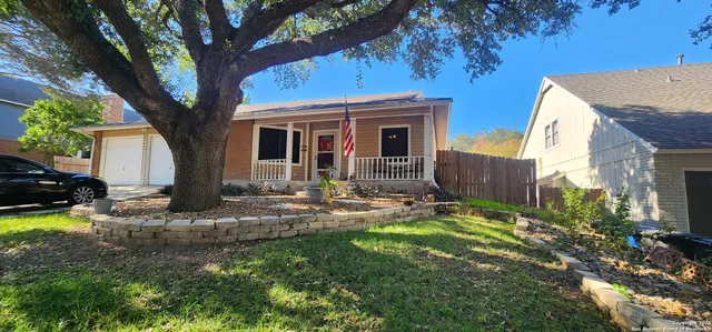 a view of a house with backyard and sitting area