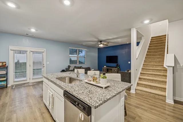 a kitchen with granite countertop attached living room