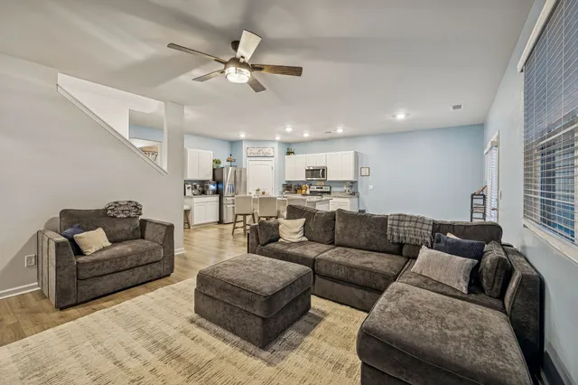 a living room with furniture and kitchen view