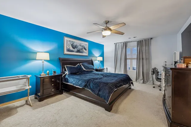 a spacious bedroom with a bed and a chandelier
