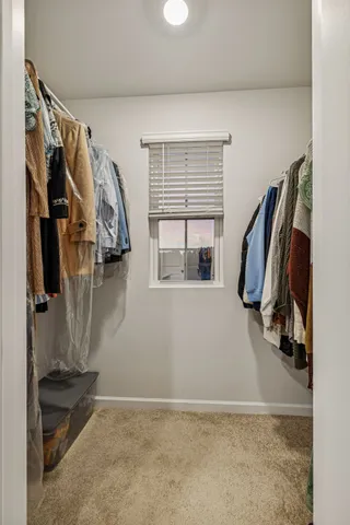 a view of walk in closet with clothes and shoes