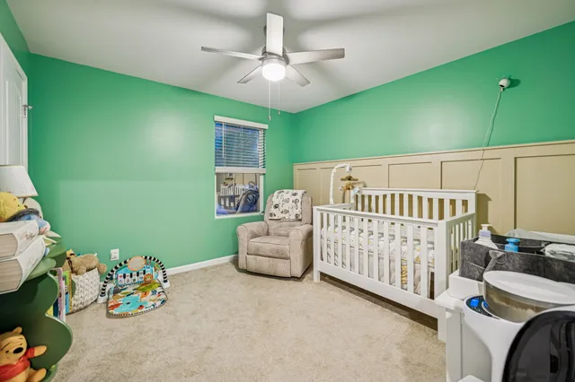 a bedroom with furniture and a chandelier fan