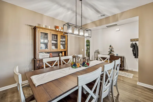 a view of a dining room and livingroom with furniture wooden floor a chandelier