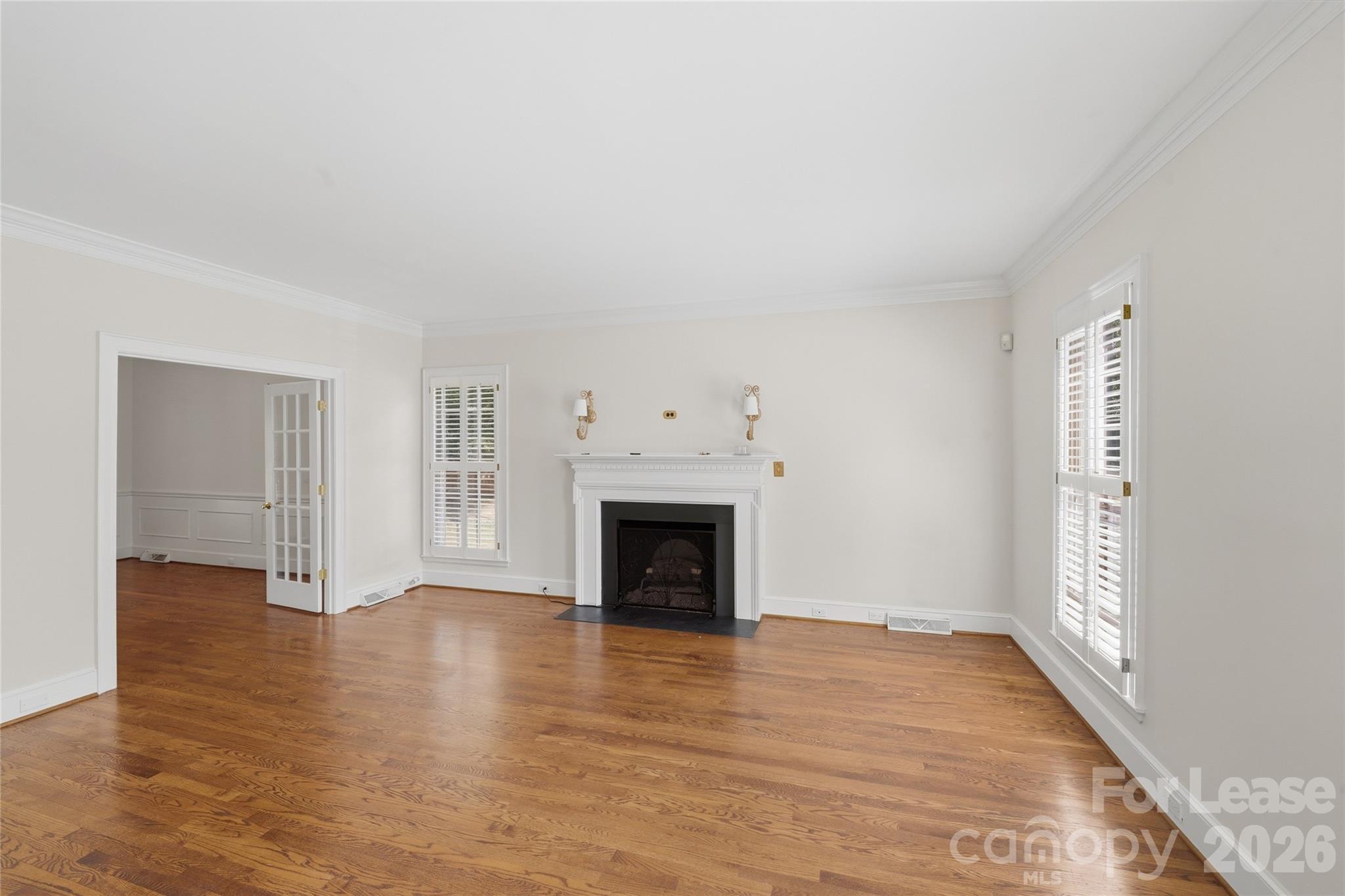 5906 Sharon Hills Road Charlotte, NC 28210 - Photo 8 of 30 an empty room with wooden floor fireplace and windows