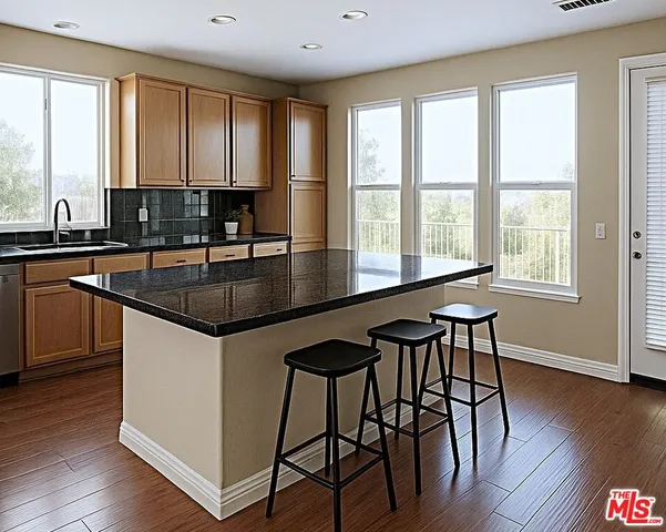 a kitchen with granite countertop a stove a sink and wooden floor