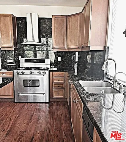 a kitchen with stainless steel appliances granite countertop a stove a sink and a microwave