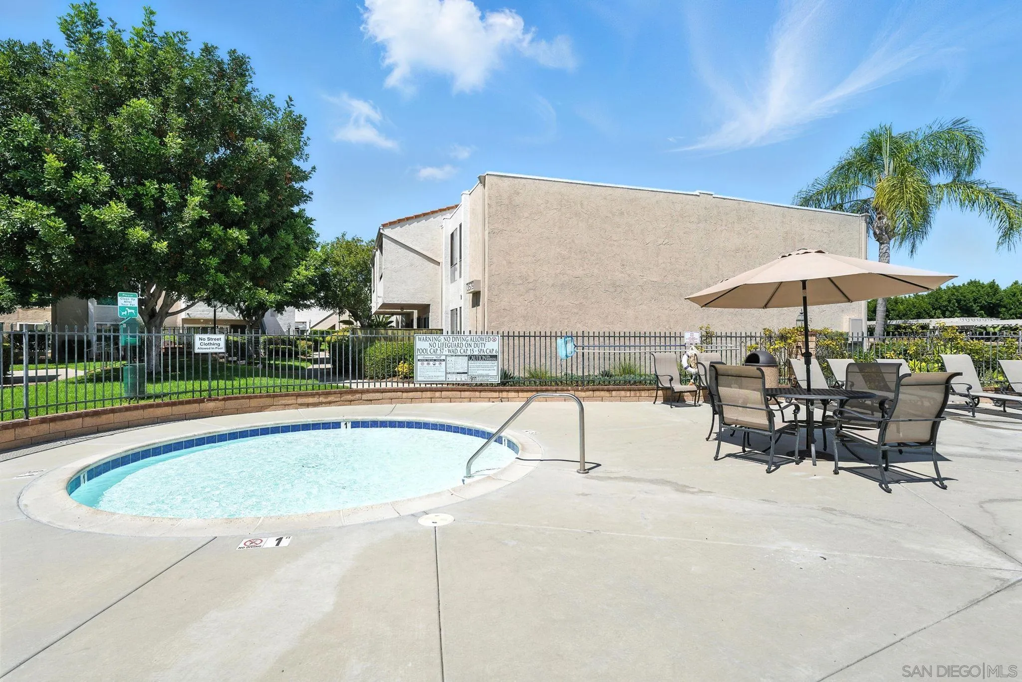 3575 Ruffin Road, Unit 204 San Diego, CA 92123 - Photo 26 of 29 a view of a swimming pool with a table and chairs under an umbrella