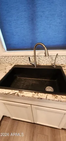 a kitchen with granite countertop a refrigerator stove and sink