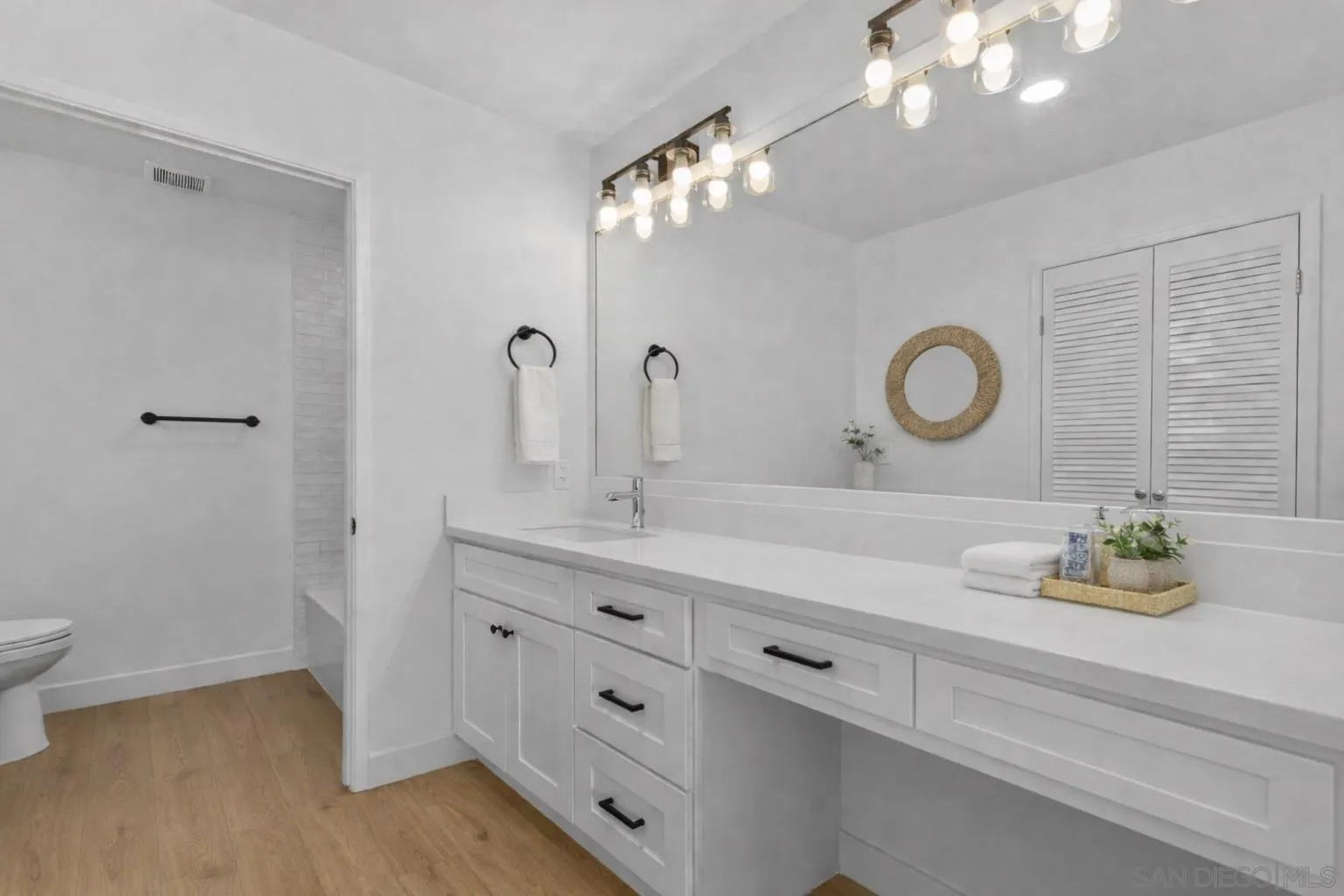 6747 Friars Road, Unit 130 San Diego, CA 92108 - Photo 17 of 32 a bathroom with a sink a large mirror and vanity