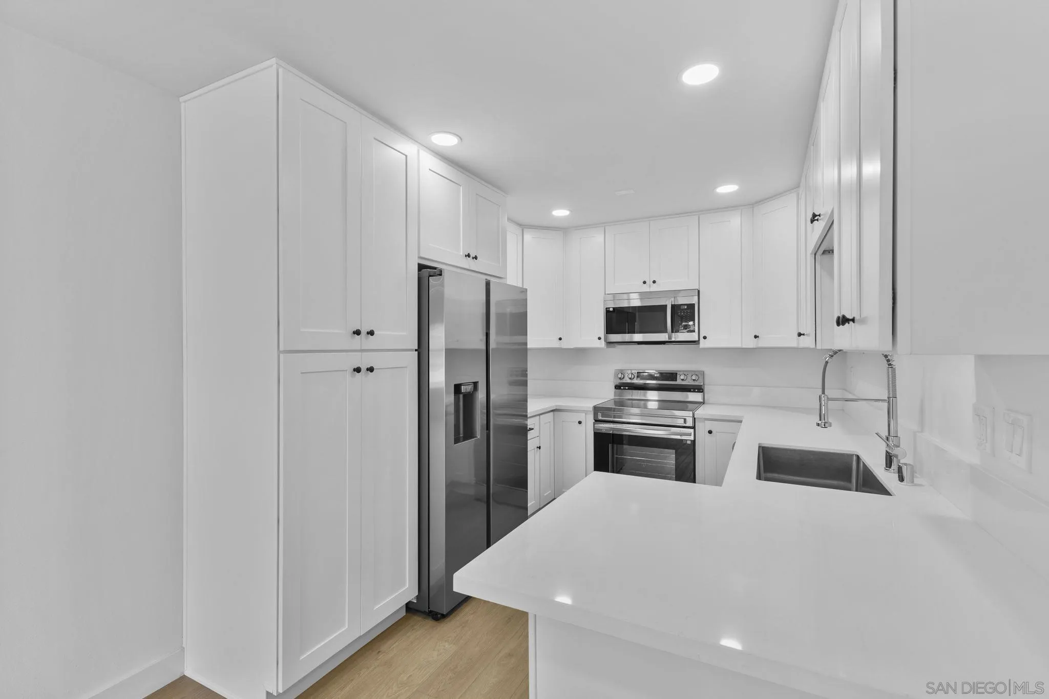 6747 Friars Road, Unit 130 San Diego, CA 92108 - Photo 2 of 32 a kitchen with refrigerator a stove top oven and cabinets