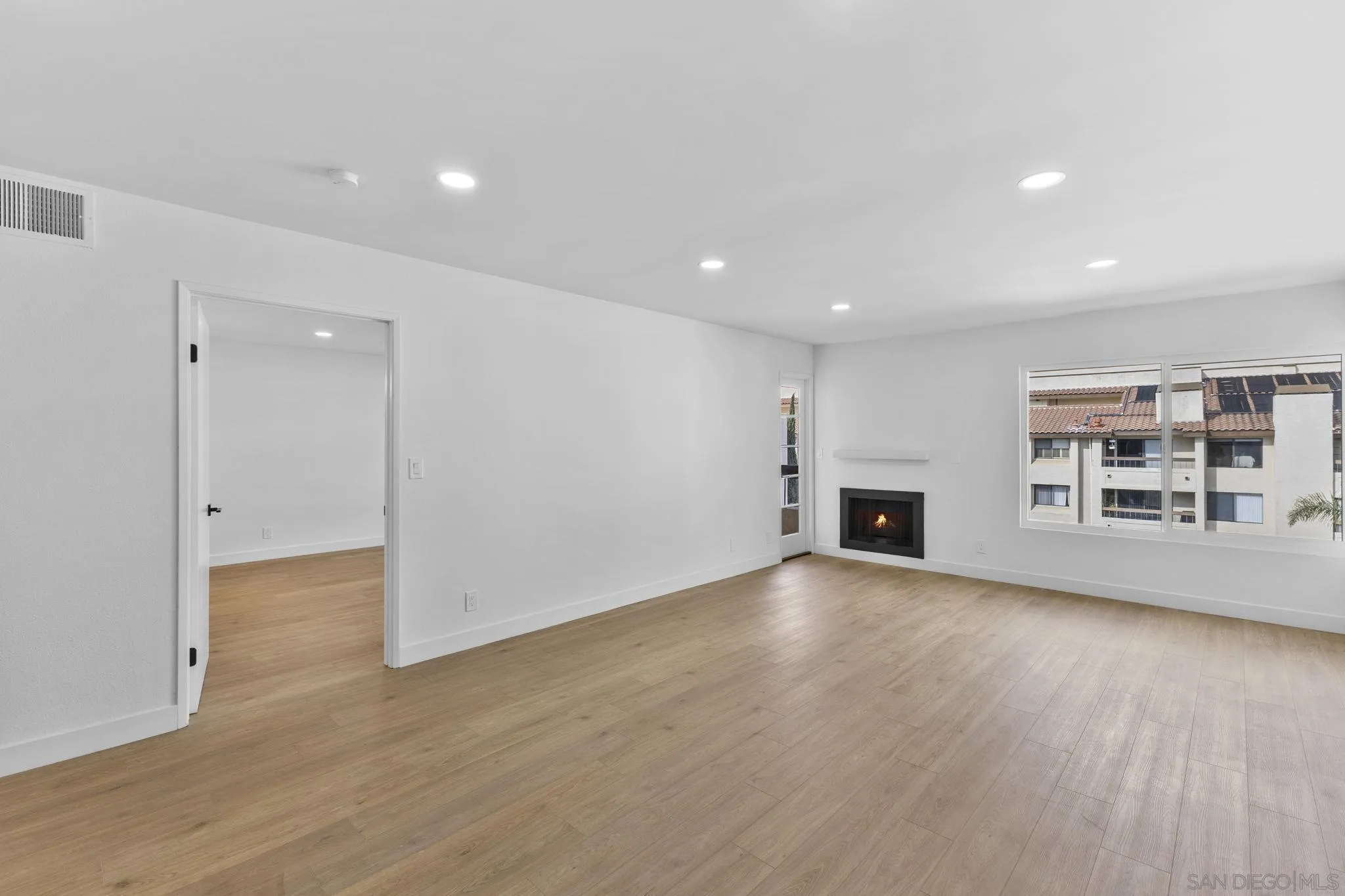 6747 Friars Road, Unit 130 San Diego, CA 92108 - Photo 10 of 32 an empty room with wooden floor and fireplace