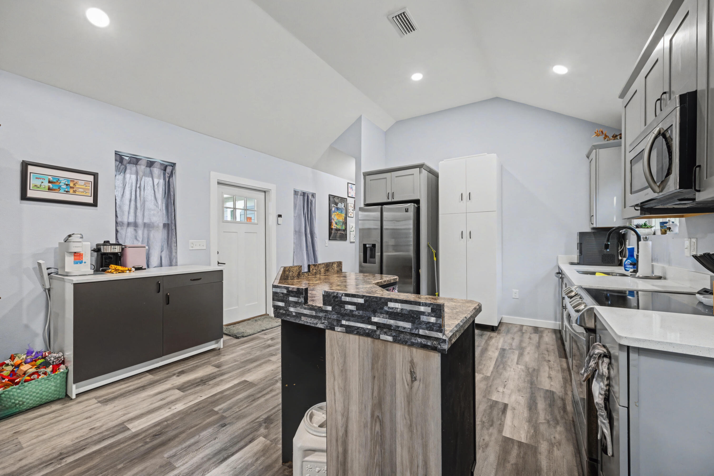 255 West Renoir Road DeFuniak Springs, FL 32433 - Photo 7 of 30 a kitchen with stainless steel appliances kitchen island granite countertop a refrigerator a stove and a sink with wooden floor