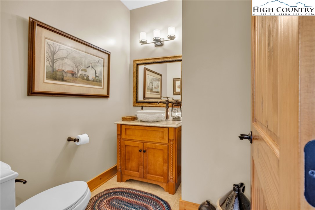 2650 Carson Woods Road Laurel Springs, NC 28644 - Photo 25 of 50 a bathroom with a granite countertop toilet a sink and mirror